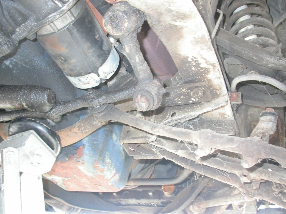 Undercarriage view showing suspension components, starter motor, and oil pan