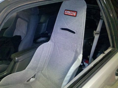1986 Ford Mustang - Interior view of a car with aftermarket racing seats and a visible seatbelt.
