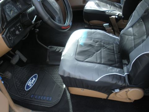 1990 Ford Bronco - Interior view of a 1990 Ford Bronco, custom seat covers and Ford-branded floor mats.