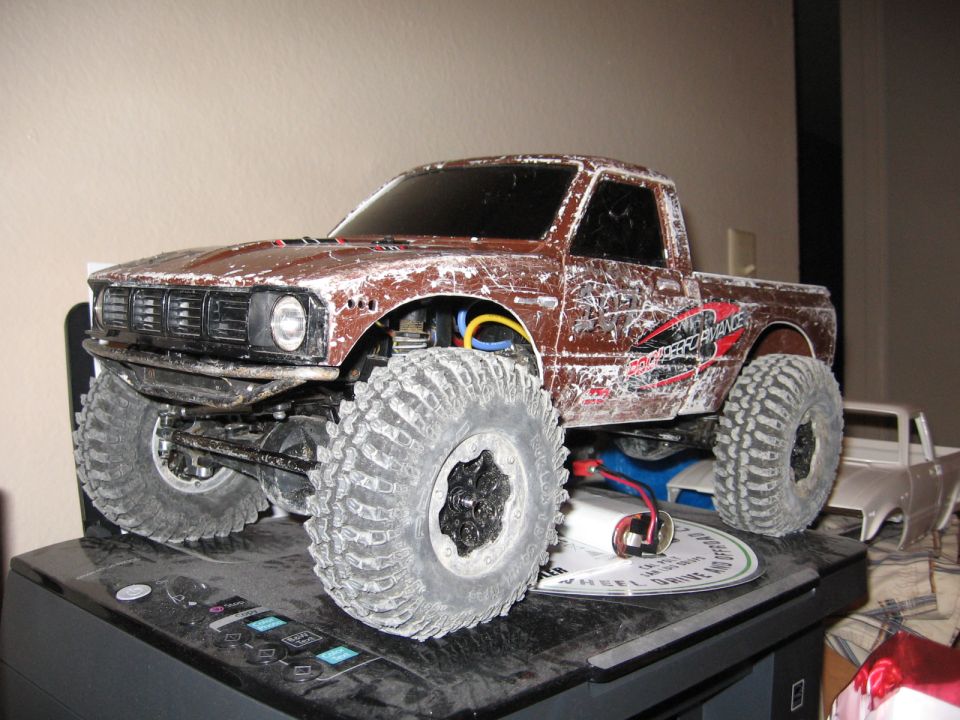 Brown remote control truck with large tires, weathered body, and "Performance" decal on the side