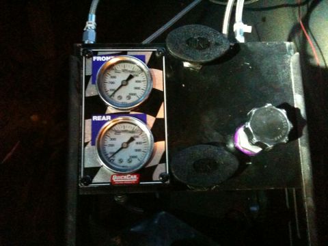 1989 Ford Bronco - Dual gauge setup for front and rear pressure readings, branded QuickCar. A cap is visible with purple tape.