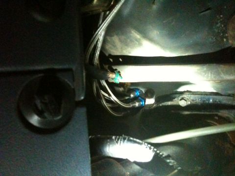 1989 Ford Bronco - Close-up of wiring and plumbing components visible inside a vehicle's interior.