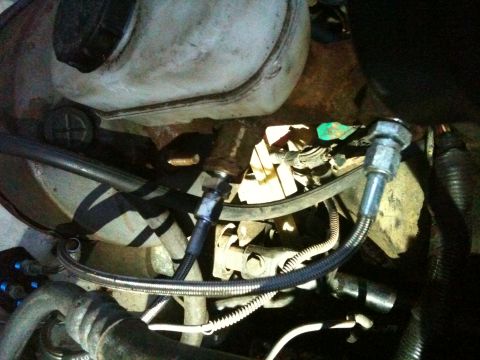 1989 Ford Bronco - Engine bay components including hoses and a fluid reservoir are visible in this close-up shot.