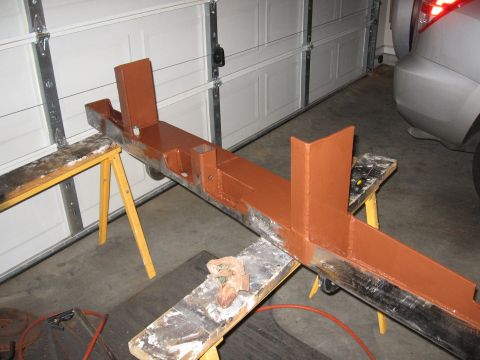 1995 Ford F-150 - A metal bumper frame, painted orange, is supported by sawhorses in a garage.