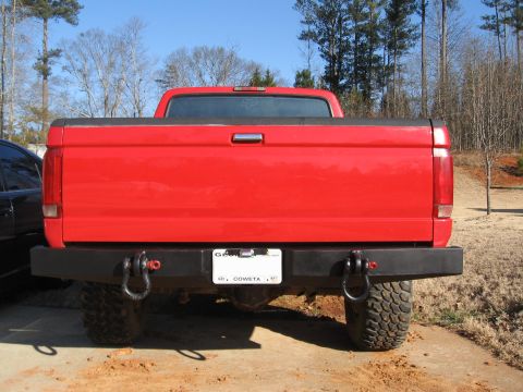 1995 Ford F-150 - Rear view of a red 1995 Ford F-150 pickup truck with an aftermarket bumper and tow hooks.
