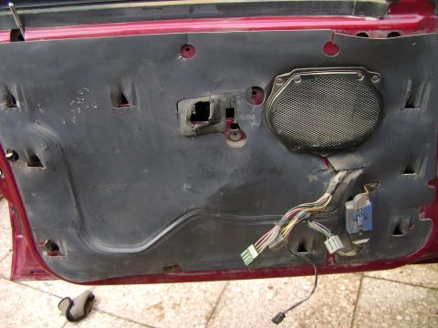 1998 Ford Crown Victoria - The interior of a car door is exposed, revealing the speaker and a bundle of electrical wires.