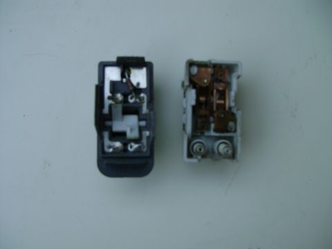 1998 Ford Crown Victoria - Two electrical relays are shown side-by-side, one with a black casing and the other with a white casing.