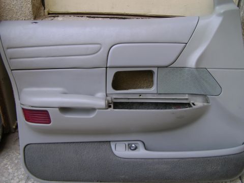 1998 Ford Crown Victoria - Interior door panel removed from a vehicle, showing the speaker grille and an empty storage compartment. The Supermotors.net logo is visibl…