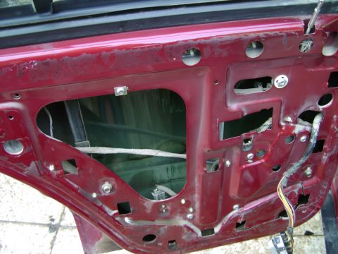 1998 Ford Crown Victoria - The interior of a car door is exposed, revealing the internal components and wiring harness.