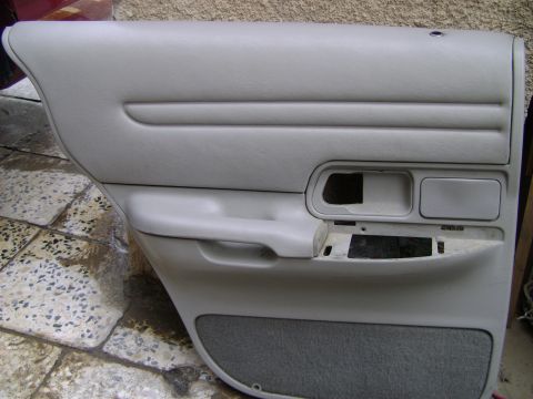 1998 Ford Crown Victoria - Interior door panel removed from a vehicle, showing the speaker grille and handle area.
