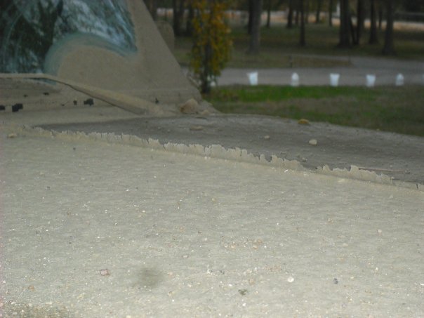 Close-up of a dusty vehicle dashboard and cracked windshield with trees in the background. Supermotors.net logo visible