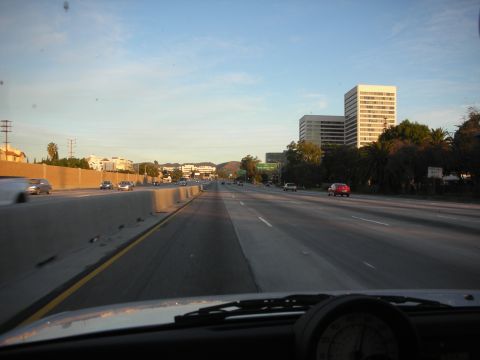 1992 Ford Crown Victoria - Driving on a highway during the day with buildings and other vehicles in view.