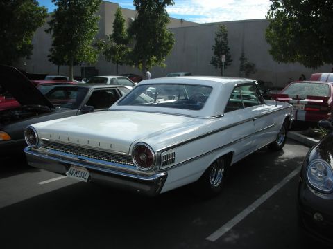 1992 Ford Crown Victoria - A white 1963 Ford Galaxie coupe is parked in a lot, showing its rear and side profile.