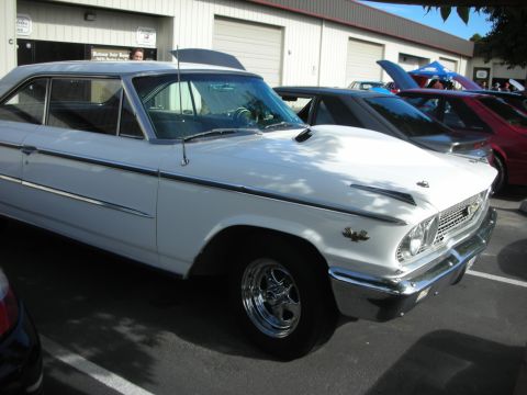 1992 Ford Crown Victoria - A white 1963 Ford Galaxie 500 is parked in front of a building with other cars behind it.