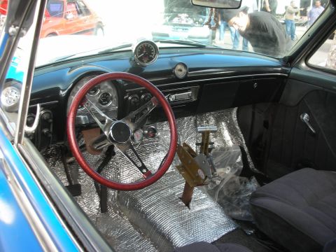 1992 Ford Crown Victoria - The interior of a classic car features a custom steering wheel and shifter, with sound-dampening material on the floor.