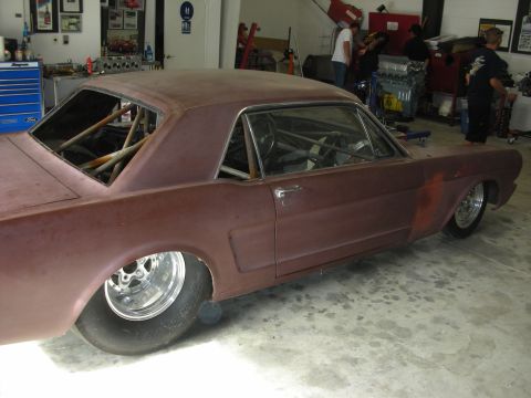 1992 Ford Crown Victoria - A vintage Ford Mustang coupe, stripped down and prepped for racing, sits in a workshop.