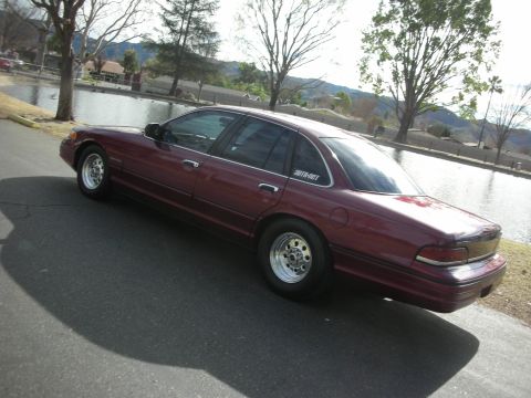 1992 Ford Crown Victoria - Maroon 1992 Ford Crown Victoria with drag wheels parked by a lake.