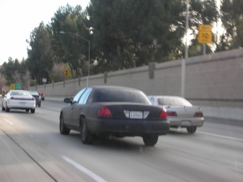 1992 Ford Crown Victoria - A black 1992 Ford Crown Victoria is seen driving on the highway alongside other vehicles.