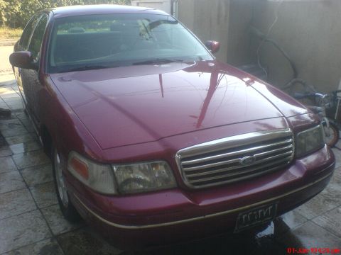 1998 Ford Crown Victoria - Front view of a maroon 1998 Ford Crown Victoria, showing its distinctive grille and headlights.