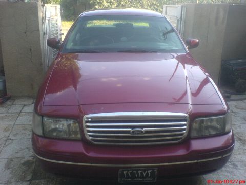 1998 Ford Crown Victoria - Front view of a red 1998 Ford Crown Victoria parked outdoors.