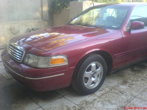 1998 Ford Crown Victoria - This 1998 Ford Crown Victoria is shown from the front passenger side, highlighting its grille and headlights.