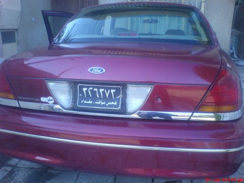 1998 Ford Crown Victoria - Rear view of a maroon 1998 Ford Crown Victoria, showing the trunk, taillights, and license plate.