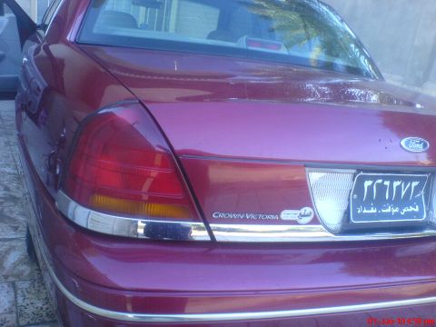 1998 Ford Crown Victoria - Rear view of a red 1998 Ford Crown Victoria, showing its taillights and trunk lid.