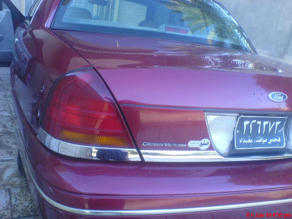 Rear view of a red 1998 Ford Crown Victoria with chrome trim and a license plate
