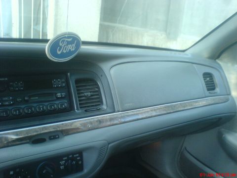 1998 Ford Crown Victoria - The dashboard of a 1998 Ford Crown Victoria, wood trim and a Ford air freshener.