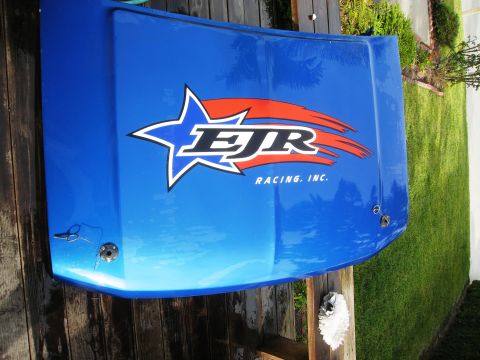 1986 Ford Bronco - A blue hood with the EJR Racing Inc. decal is displayed on a wooden surface.