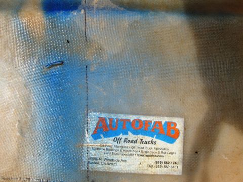 1986 Ford Bronco - Label for Autofab Off Road Trucks, listing services and contact information, affixed to a textured material.