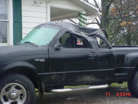 1996 Ford Bronco - This black Ford Ranger pickup truck shows significant damage to its roof, impacting its overall structure.