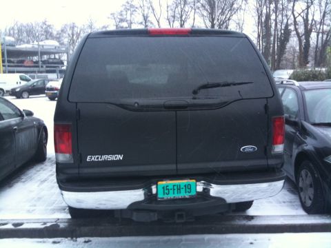 2005 Ford Excursion - Rear view of a black Ford Excursion parked in a snowy lot.