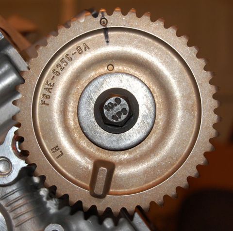 2007 Ford Mustang - A close-up view of a vehicle's engine timing gear, showing part number F8AE-6256-BA and a bolt.