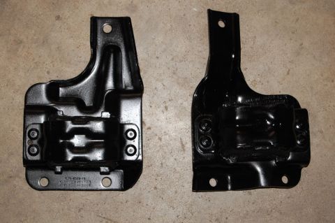 2007 Ford Mustang - Two black metal brackets are shown side-by-side on a concrete surface.