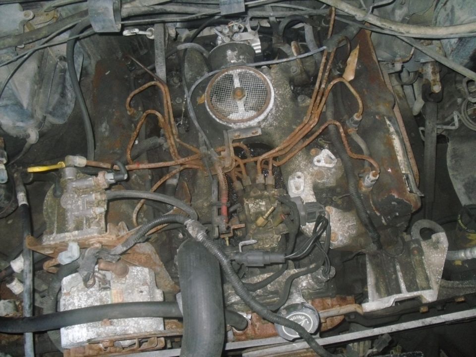 Engine bay with rusty fuel lines and air intake