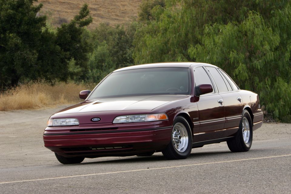 Maroon Ford full-size sedan, front three-quarter view, lowered on polished five-spoke wheels