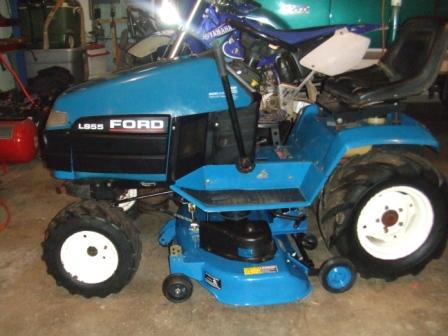 1996 Ford Bronco - A blue Ford L855 tractor is parked indoors, with a dirt bike visible in the background.