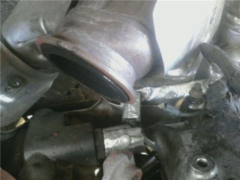 1995 Ford Bronco - Close-up view of engine components, including exhaust and wiring.