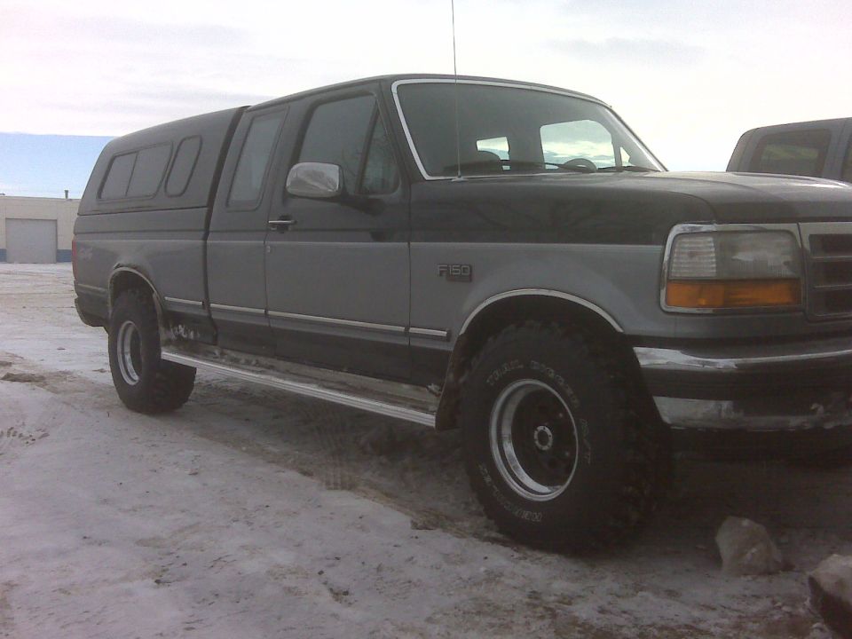 1994 Ford F-150 pickup truck, two-tone gray and black, with camper shell