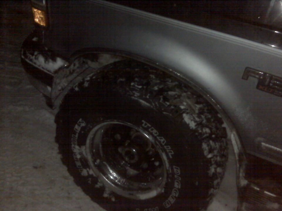 1994 Ford F-150 fender with snow on it, showing the front tire and part of the headlight