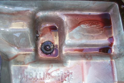 1992 Ford C-350 (Centurion Conversions) - Close-up of a transmission pan showing fluid levels and a Ford emblem.