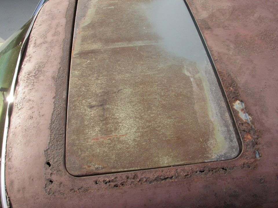 Rusted car roof section with sunroof opening
