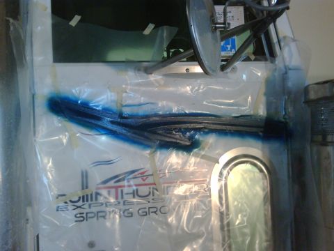 2003 Peterbilt 379 - Truck door is covered in plastic for painting, showing blue spray paint detail and company text.