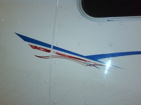 2003 Peterbilt 379 - Close-up of a truck's side panel showing a blue and red graphic decal and a window.