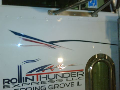 2003 Peterbilt 379 - Close-up of a white truck door displaying company graphics and text.