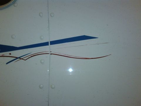 2003 Peterbilt 379 - Close-up of a white panel with blue and red stripe decals, rivets, and a seam.