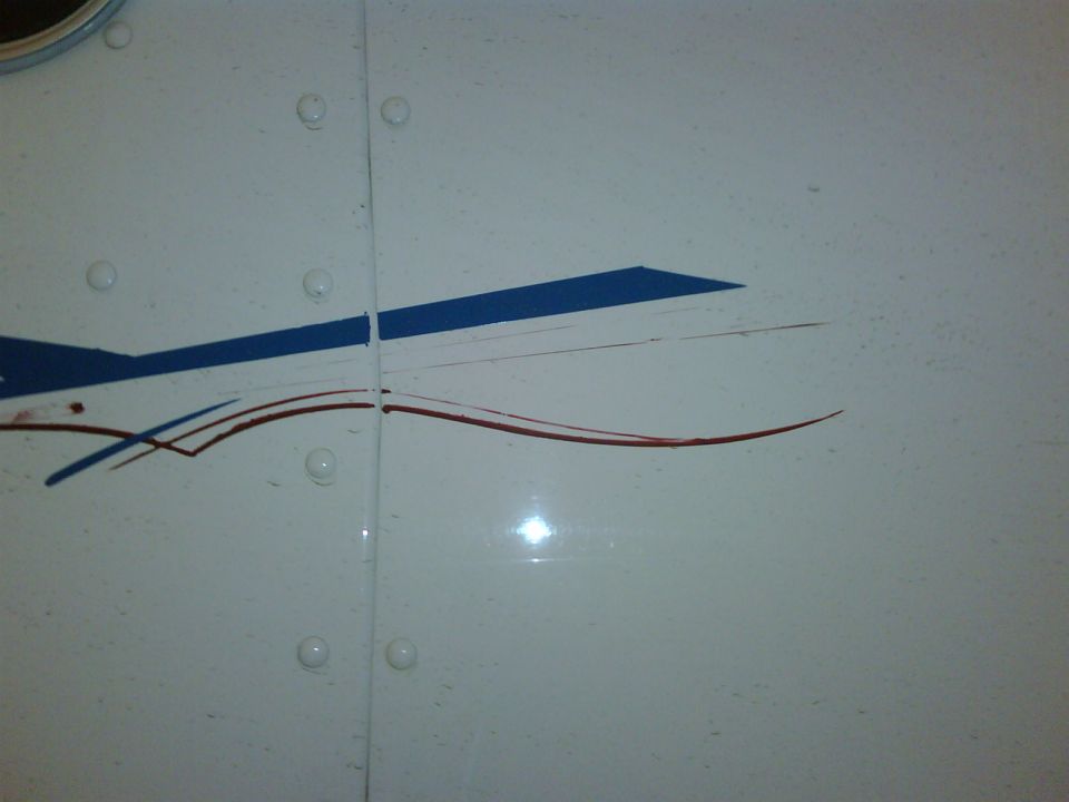 White panel with blue and red stripe decals, showing rivets and a seam