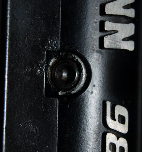 1994 Ford Bronco - Close-up of a black metal component with visible bolt and silver lettering.