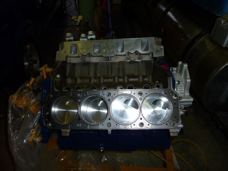 Engine block with pistons visible, on an engine stand